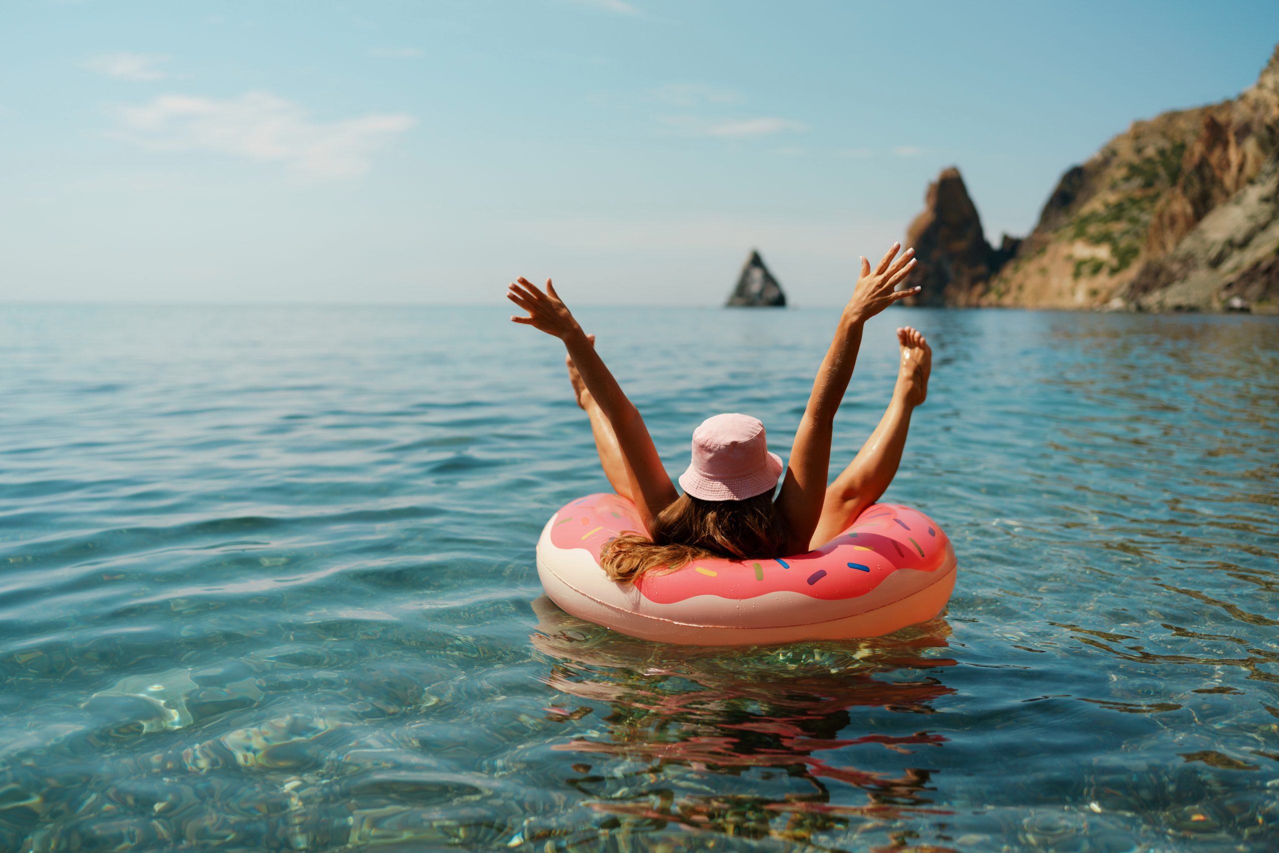 Eine Frau liegt im Schwimmreifen im Meer