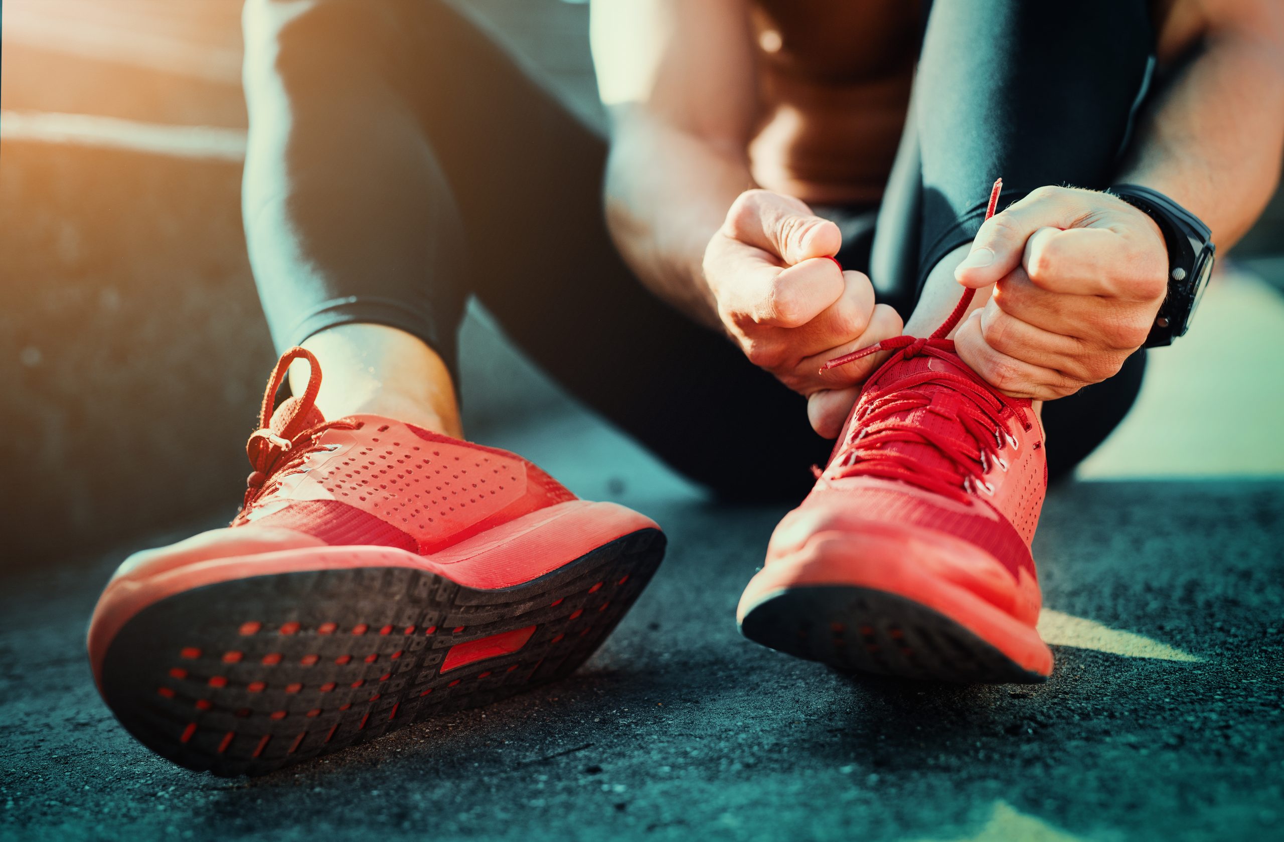 Eine Person bindet sich die Sportschuhe zu