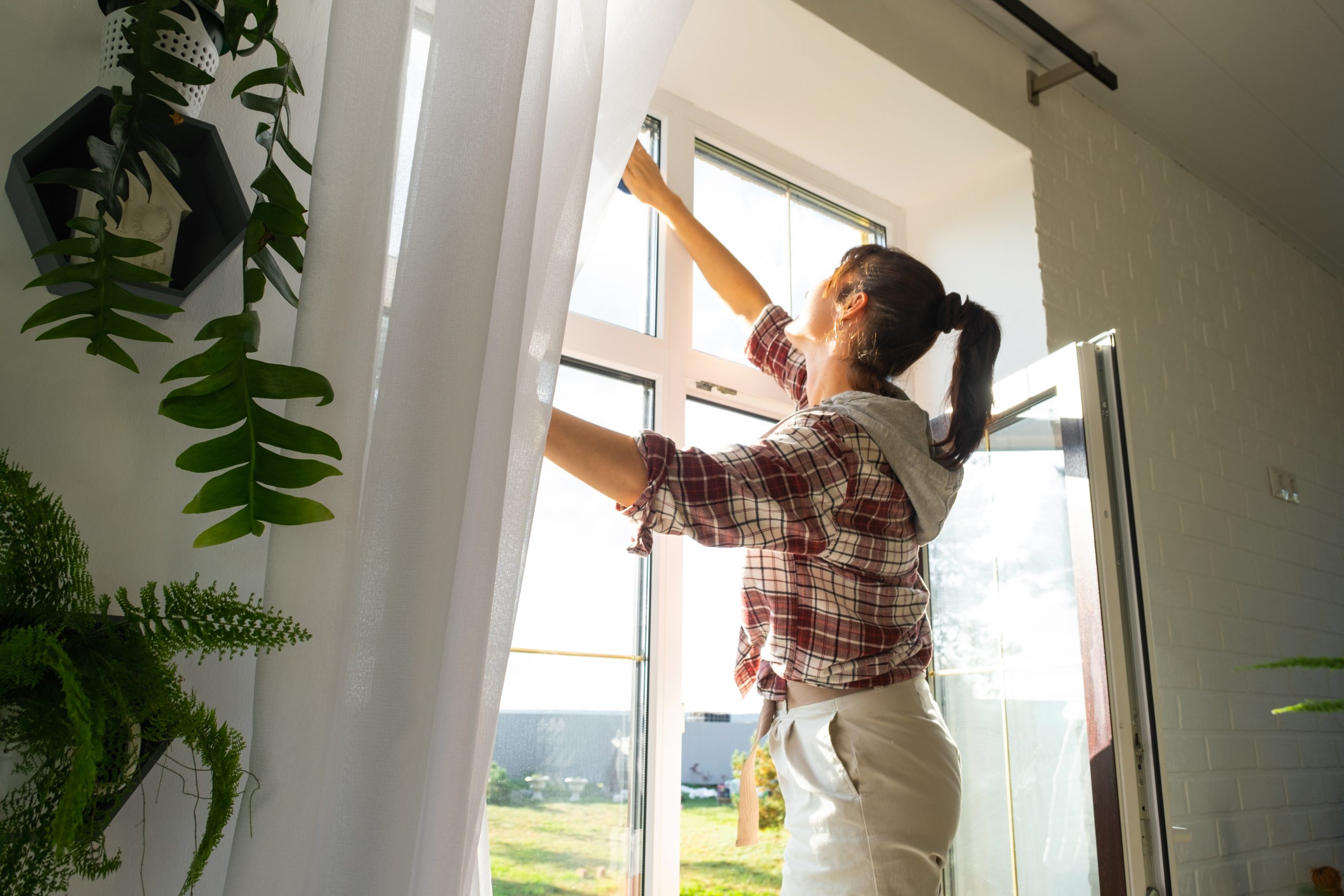 Eine Frau öffnet ein Fenster